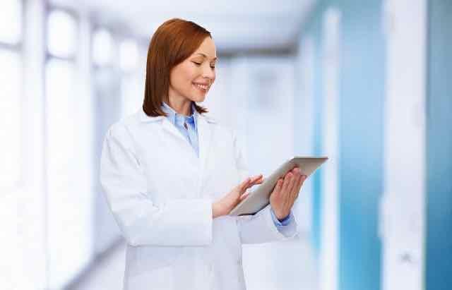 medica feliz usando um tablet