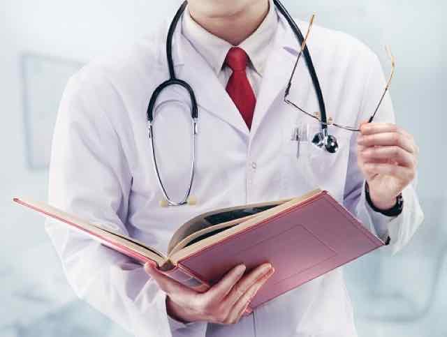 médico com estetoscopio e um livro na mão