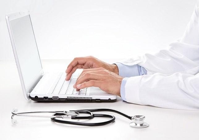 médico escrevendo em computador para uso de telemedicina
