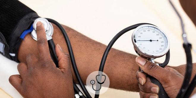 mão de médico aferindo pressão de paciente com hipotensão ortostática