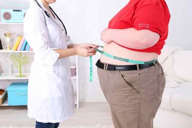 médica medindo circuferencia abdominal de paciente obeso
