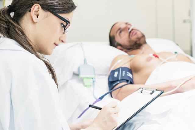 médica medindo a pressao arterial de paciente na UTI