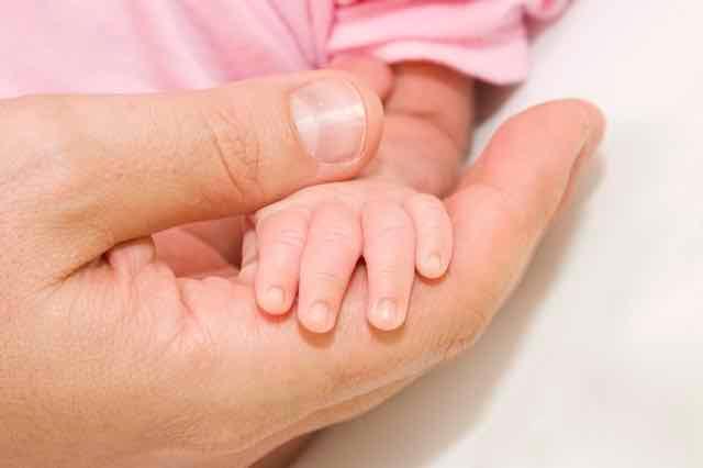 pai segurando a mão de bebe