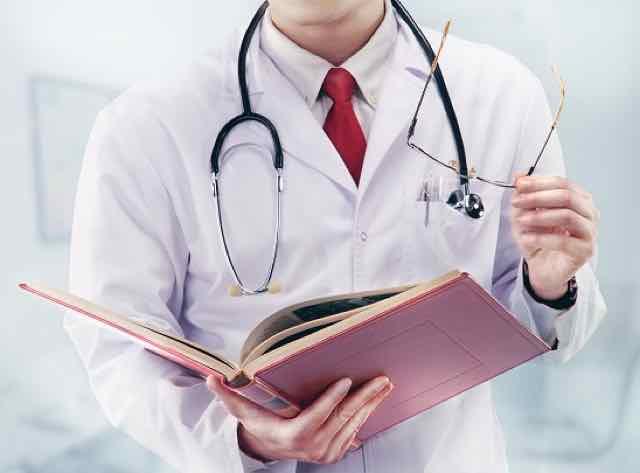 medico com livro na mão