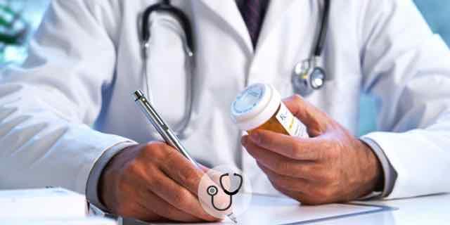 médico segurando um remédio e preenchendo uma prescrição