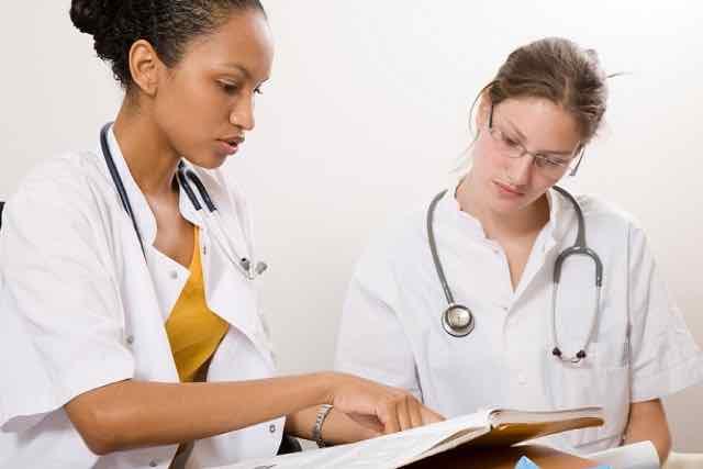 duas estudantes de medicina olhando livros