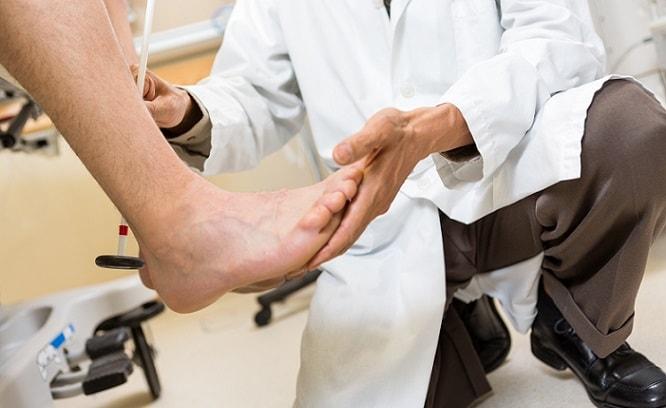 médico examinando pé do paciente com osteomielite