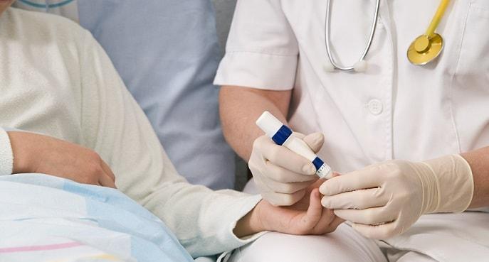 médica medindo glicose em paciente com diabetes