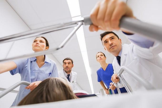 médico e enfermeiros levando maca com paciente com sepse para a internação