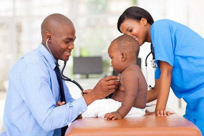médico e enfermeira realizando consulta em menino com cardiopatia congênita