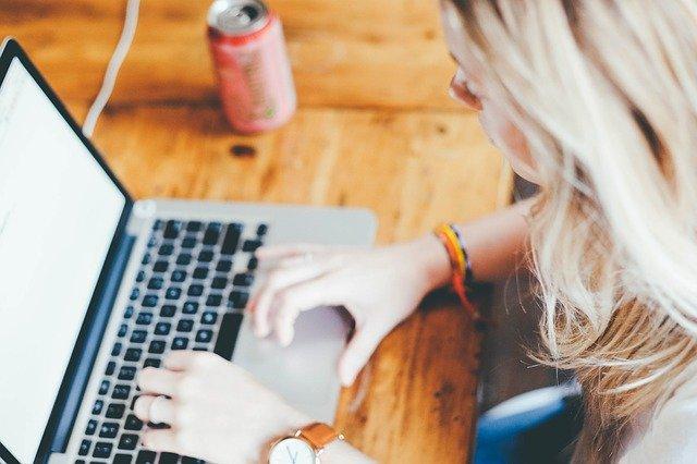 mulher digitando em laptop, utilizando tecnologias educacionais