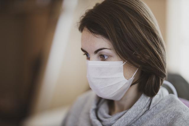 mulher usando máscara por conta da Covid-19