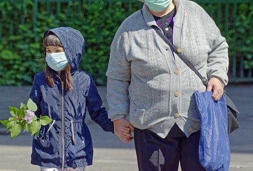 Criança passeia com o responsável durante a pandemia de Covid-19 se atentando às instruções de proteção para evitar uma infecção pelo vírus