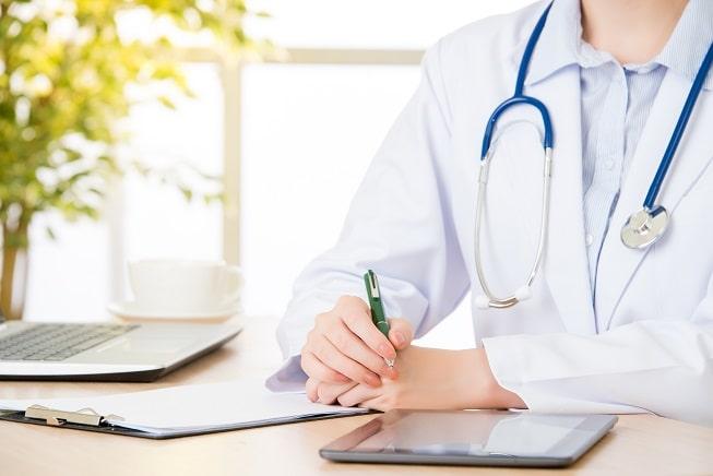 médico anotando informações de paciente com Covid-19