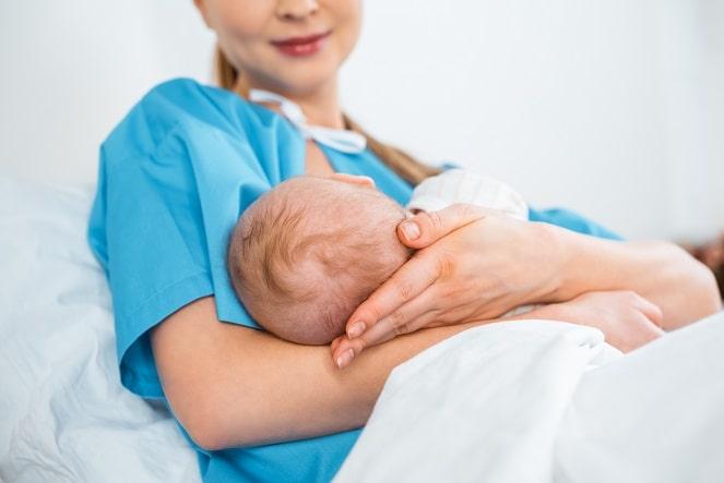 mão segurando bebê recém-nascido em hospital