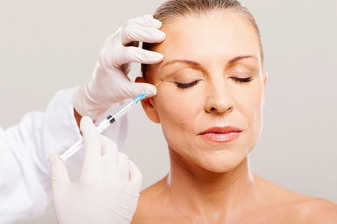 mulher com envelhecimento facial recebendo injeção de botox