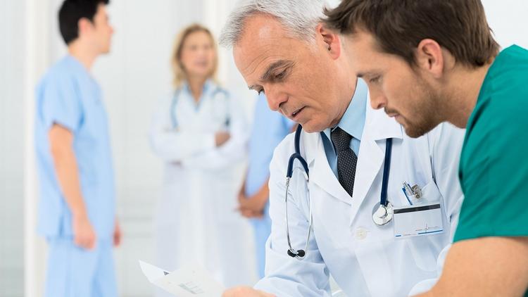 Médicos analisando o estudo sobre hemorragia alveolar difusa