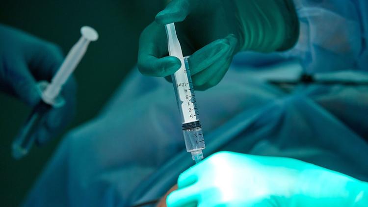 Close de médico aplicando anestésicos locais