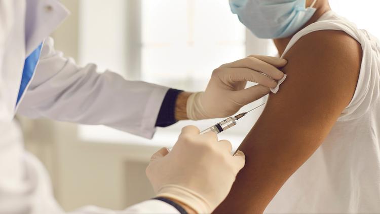 Enfermeiro aplicando vacina contra a dengue em criança